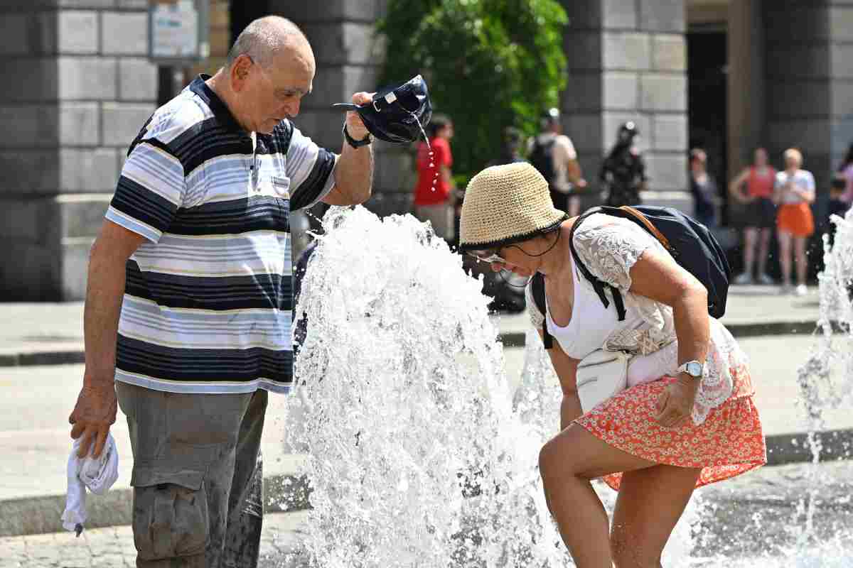 Anziani che si rinfrescano presso una fontana