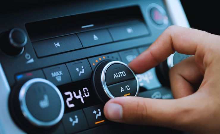 mano che accende aria condizionata in auto