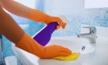 mani con guanti lavano un lavandino del bagno