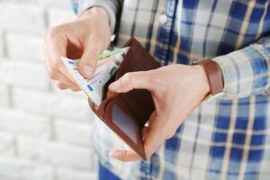 uomo tira fuori banconote da portafogli
