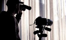 uomo spia con cannocchiale e videocamera