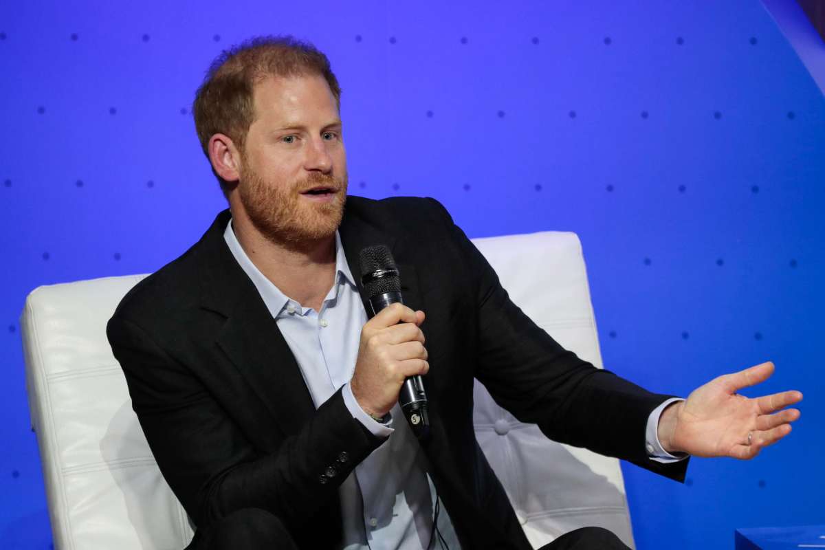 Il principe Harry parla al microfono e seduto in poltrona