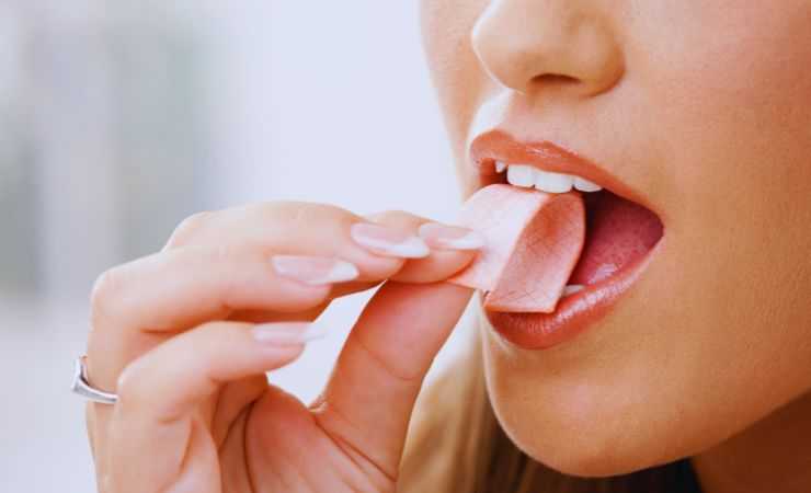 ragazza mangia gomma da masticare