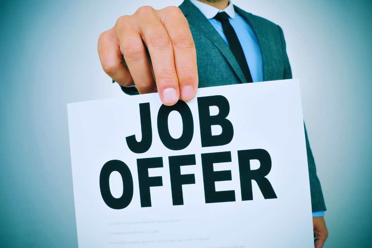 persona con cartello con scritto offerta di lavoro