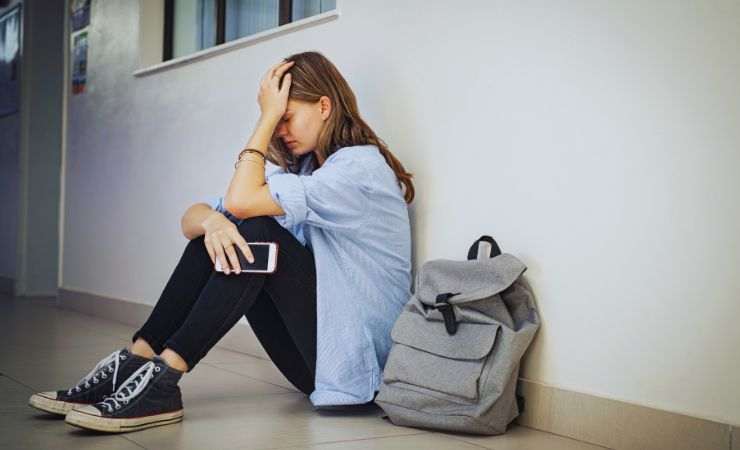 ragazza disperata seduta a terra